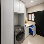 Custom European laundry with white shaker cabinetry, marble benchtop and pull-out hamper by KJoinery Melbourne
