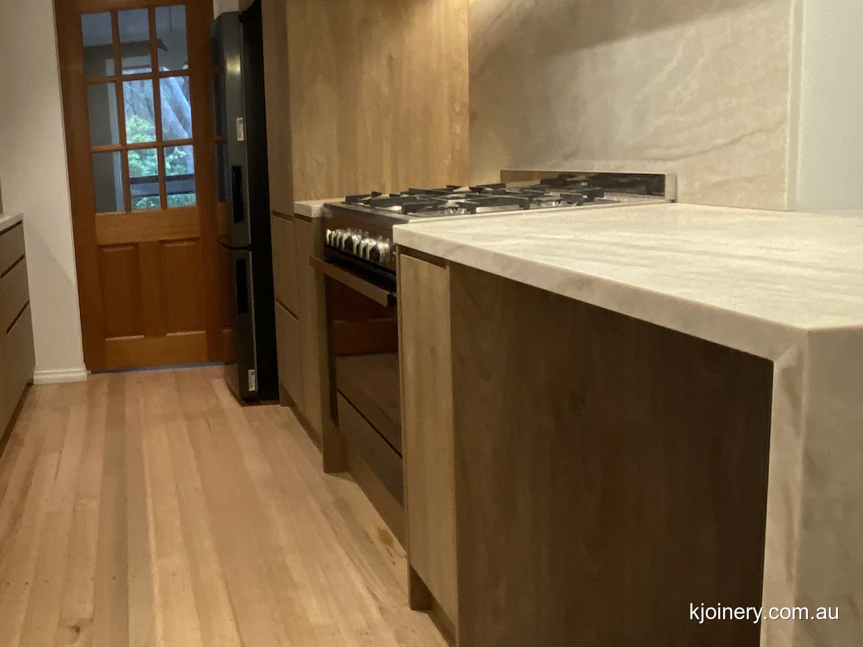 Gas cooktop and Santorini Gold stone splashback in an Essendon kitchen renovation