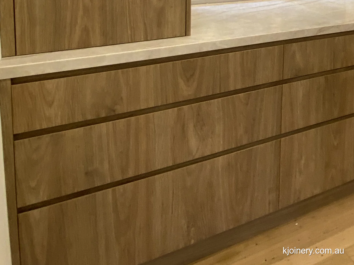 Laminex Prime Oak drawer fronts with slim finger pull rails in an Essendon kitchen