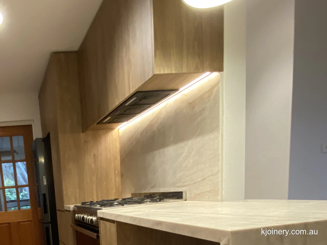 Oak cabinetry cut on an angle to follow a raked ceiling in an Essendon kitchen