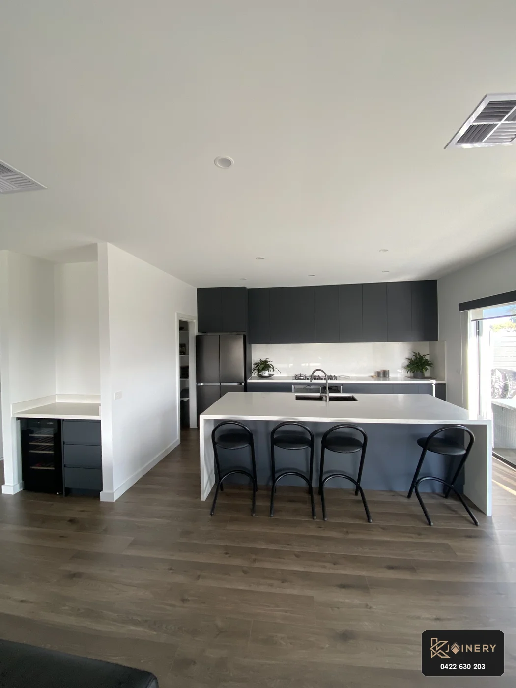 Wide open-plan view from living room looking towards kitchen island and custom wine bar in Altona
