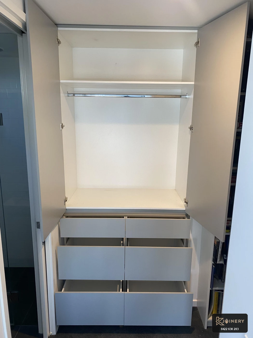 Internal view of custom wardrobe installations Footscray showing chrome hanging rail, top shelf and open Blum drawers